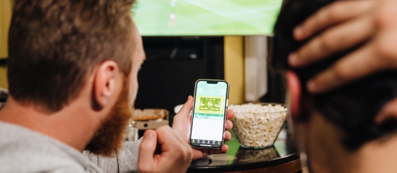 Amigos apostando e assistindo jogo de futebol