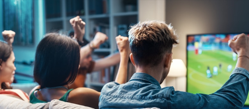 Amigos vendo jogo de futebol na TV