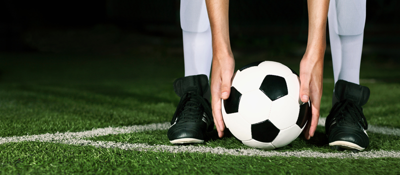 Jogador preparando bola em área de escanteio